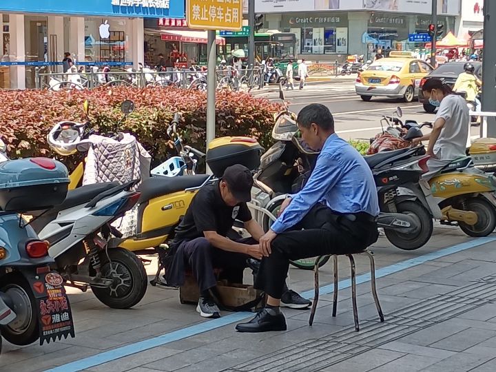身后是繁忙的公路,身前是对自己手艺的坚守截图